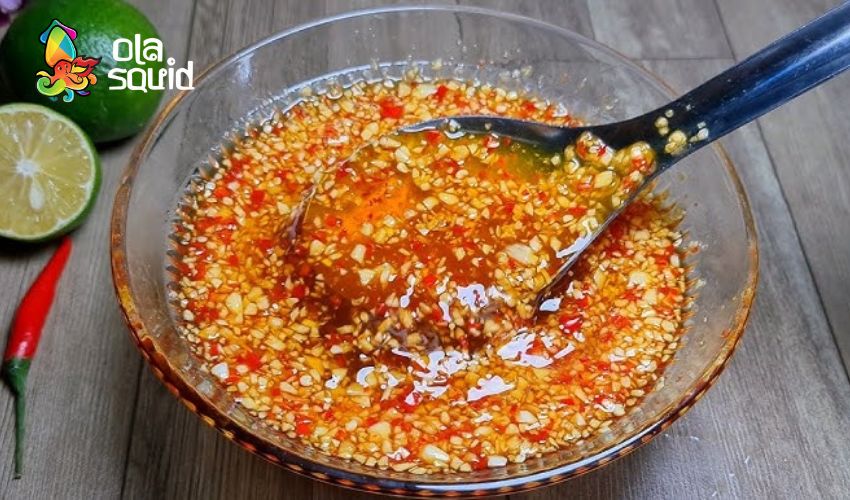 Cách làm gỏi mực chua ngọt ngon bùng vị tại nhà 3 Khi khuấy đều, hỗn hợp phải đạt trạng thái sánh, đậm đặc và có mùi thơm đồng nhất giữa nước mắm, tắc, tương ớt. Bạn nên pha dư 1 chút để chấm thêm khi ăn.