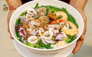 Bày các nguyên liệu rồi thêm nước dùng vào là đã xong tô hủ tiếu mực thơm ngon